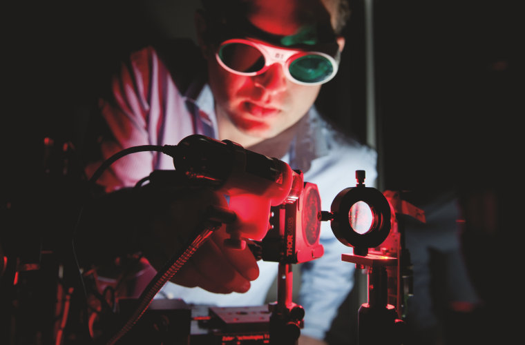 Employee of Osram Opto Semiconductors tunes experimental assembly for characterization of an red LED.